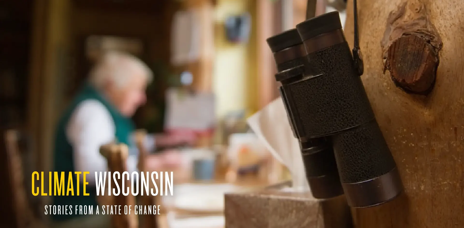 A pair of binoculars hanging up with a person out of focus in the background