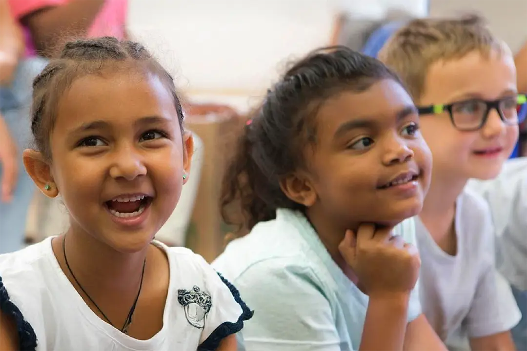 School aged children sitting in the classroom and smiling