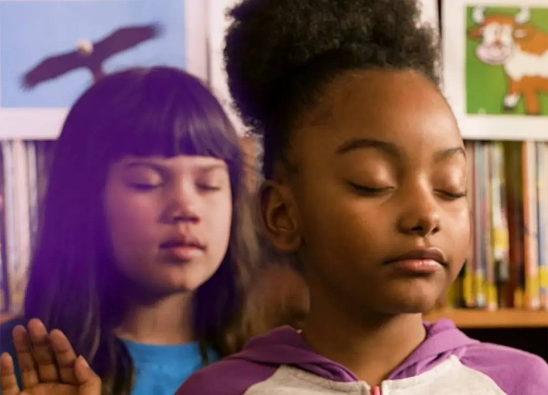 School aged children with eyes closed during a mindfulness exercise in the classroom