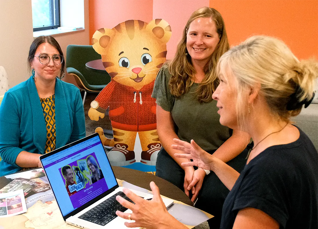 PBS Wisconsin Education staff and educators gathered around a laptop computer and working together