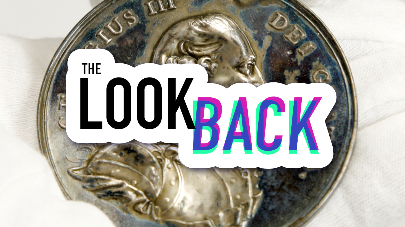 A photo of a medal with the logo for “The Look Back” superimposed