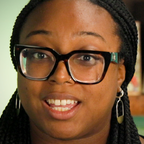 Person with long braids and dark-rimmed glasses.