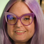Smiling person with lavender hair and purple cat-eye glasses.