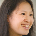 Smiling person with long dark hair.