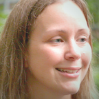 Smiling person with wavy strawberry-blond hair.